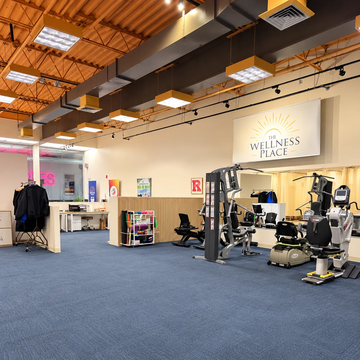 The treatment floor at The Wellness Place, Jersey City, with exercise equipment set out under a timber ceiling.